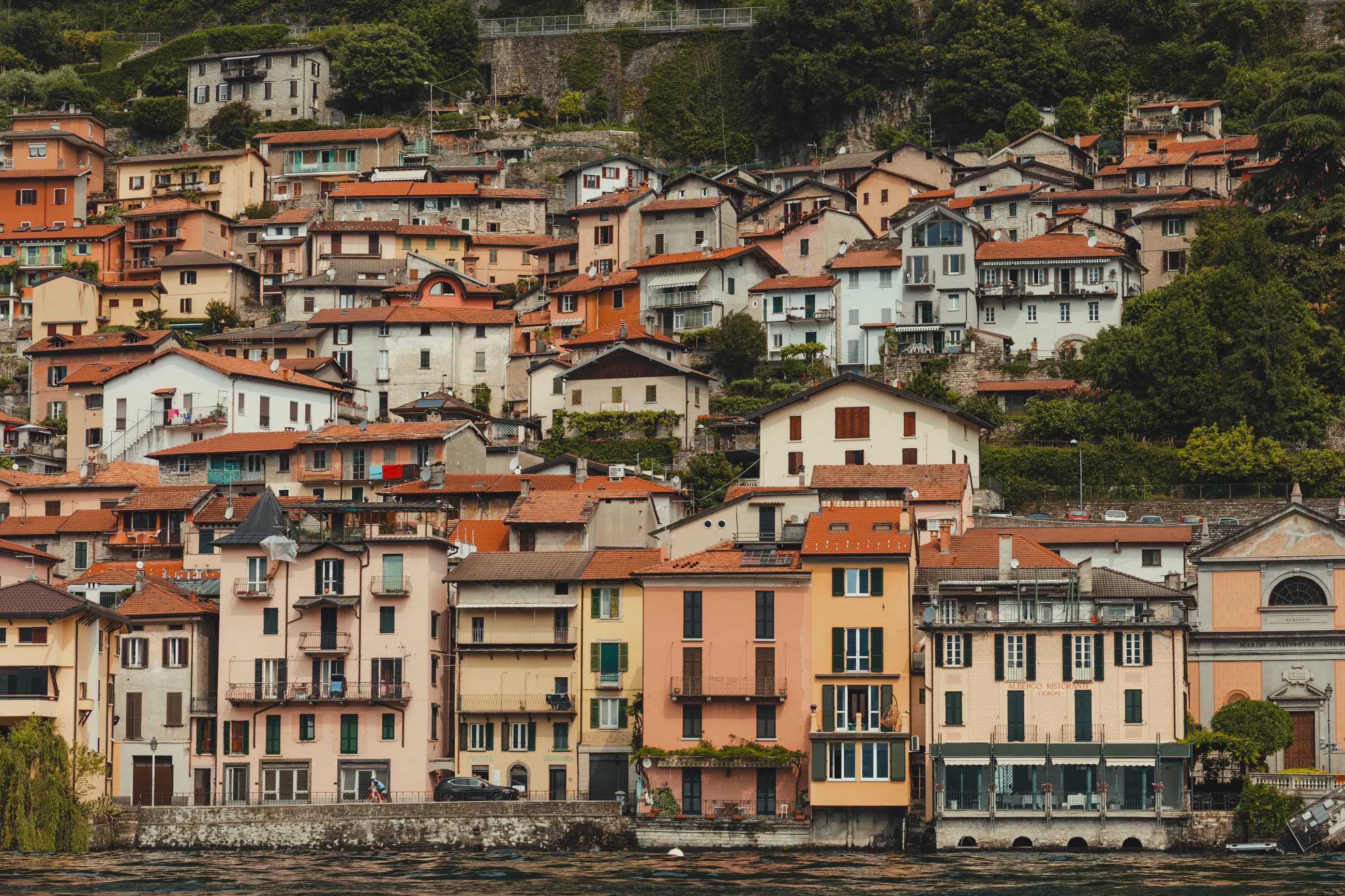 Dense pastel houses and terracotta roofs along the Lake Como waterfront